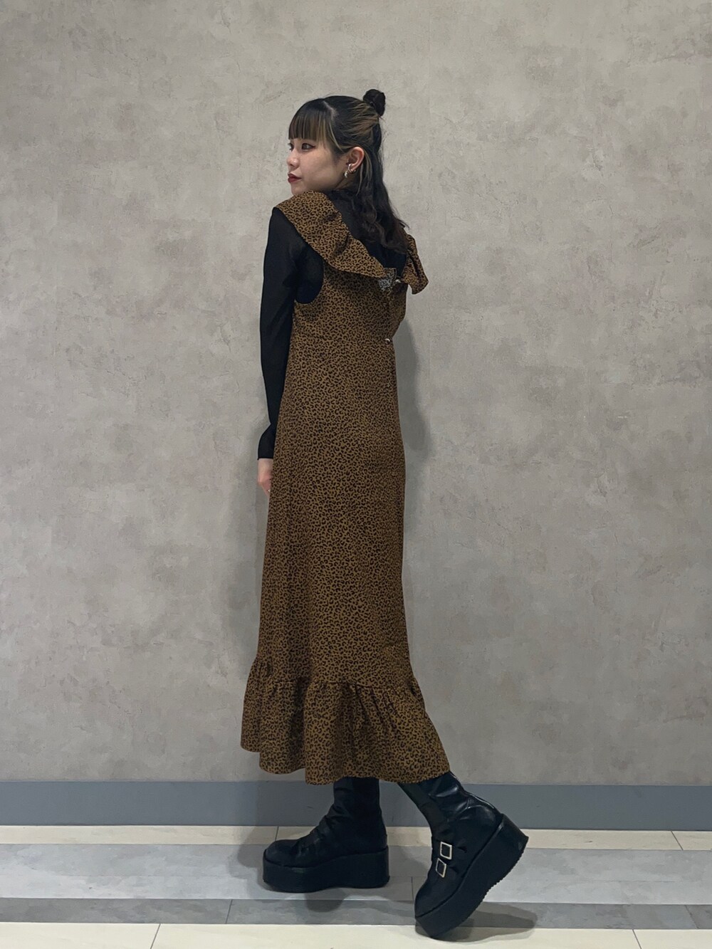 ブラウン系のワンピース、ブラック系のTシャツ/カットソー、ブラック系のブーツを着用したレディースの夏コーディネートの2枚目の写真