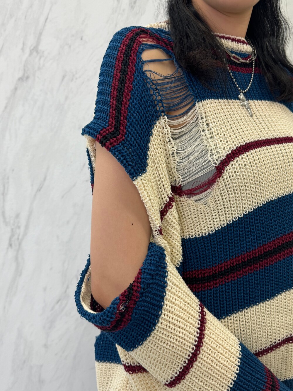 ホワイト系のニット/セーター、レッド系のスカート、ブラック系のブーツを着用したレディースの春コーディネートの6枚目の写真