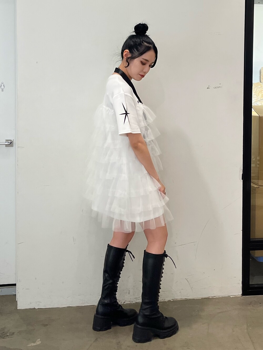 ホワイト系のワンピース、ブラック系のブーツを着用したレディースの春コーディネートの4枚目の写真