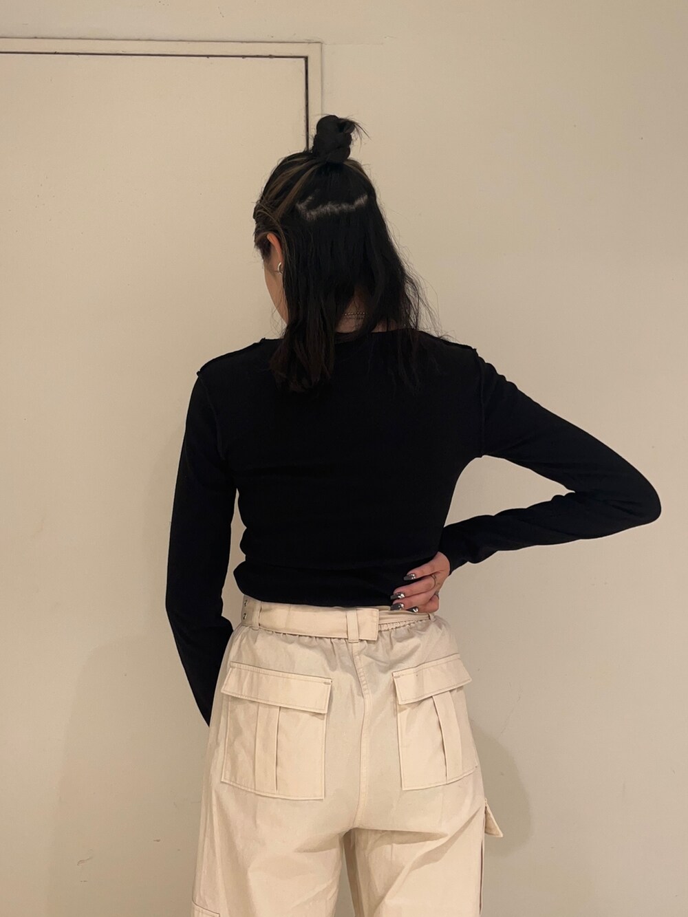 ブラック系のダウンベスト、ホワイト系のカーゴパンツ、ブラック系のTシャツ/カットソーを着用したレディースの秋コーディネートの6枚目の写真