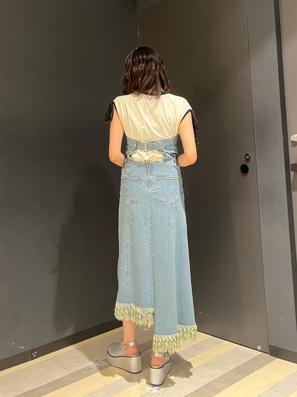 ブルー系のジャンパースカート、ホワイト系のTシャツ/カットソー、シルバー系のサンダルを着用したレディースの夏コーディネートの3枚目の写真