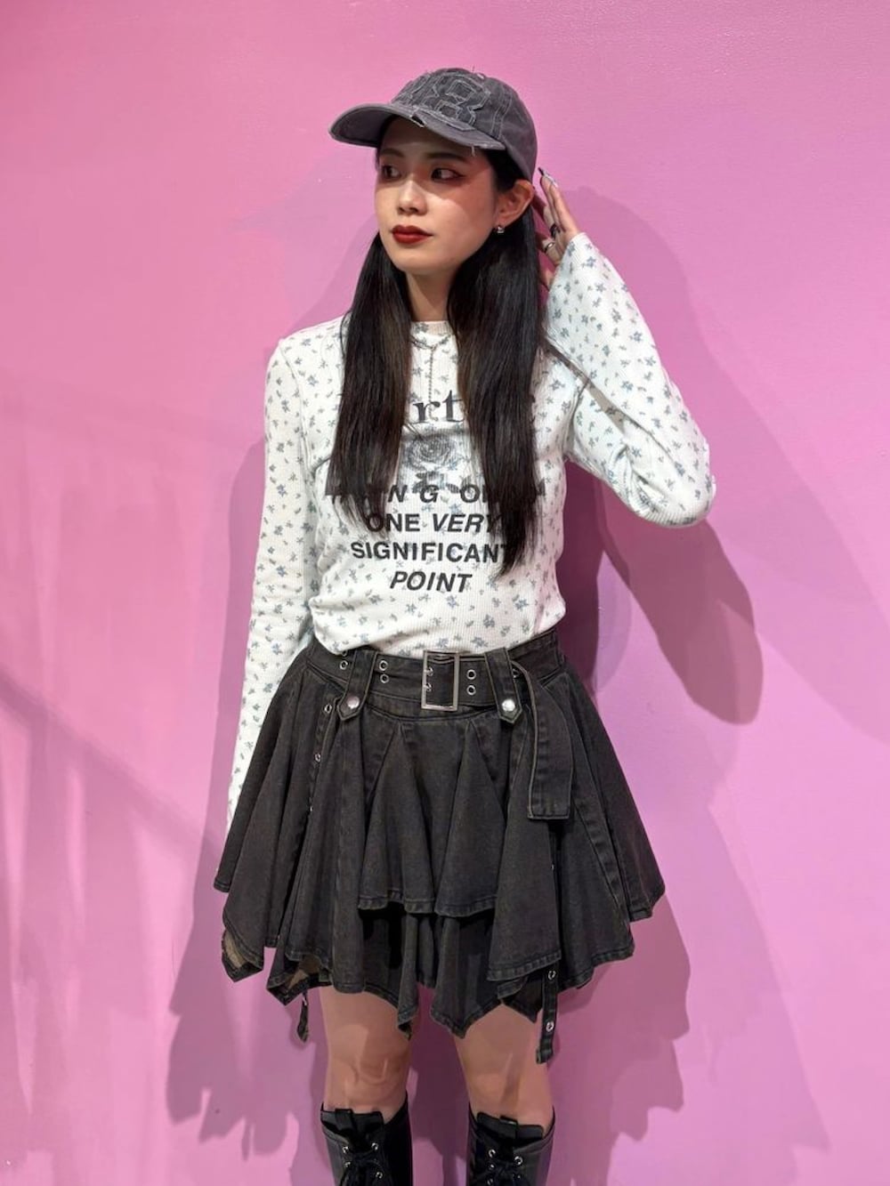 ブラック系のデニムスカート、ブラック系のブーツ、ホワイト系のTシャツ/カットソーを着用したレディースの夏コーディネートの2枚目の写真