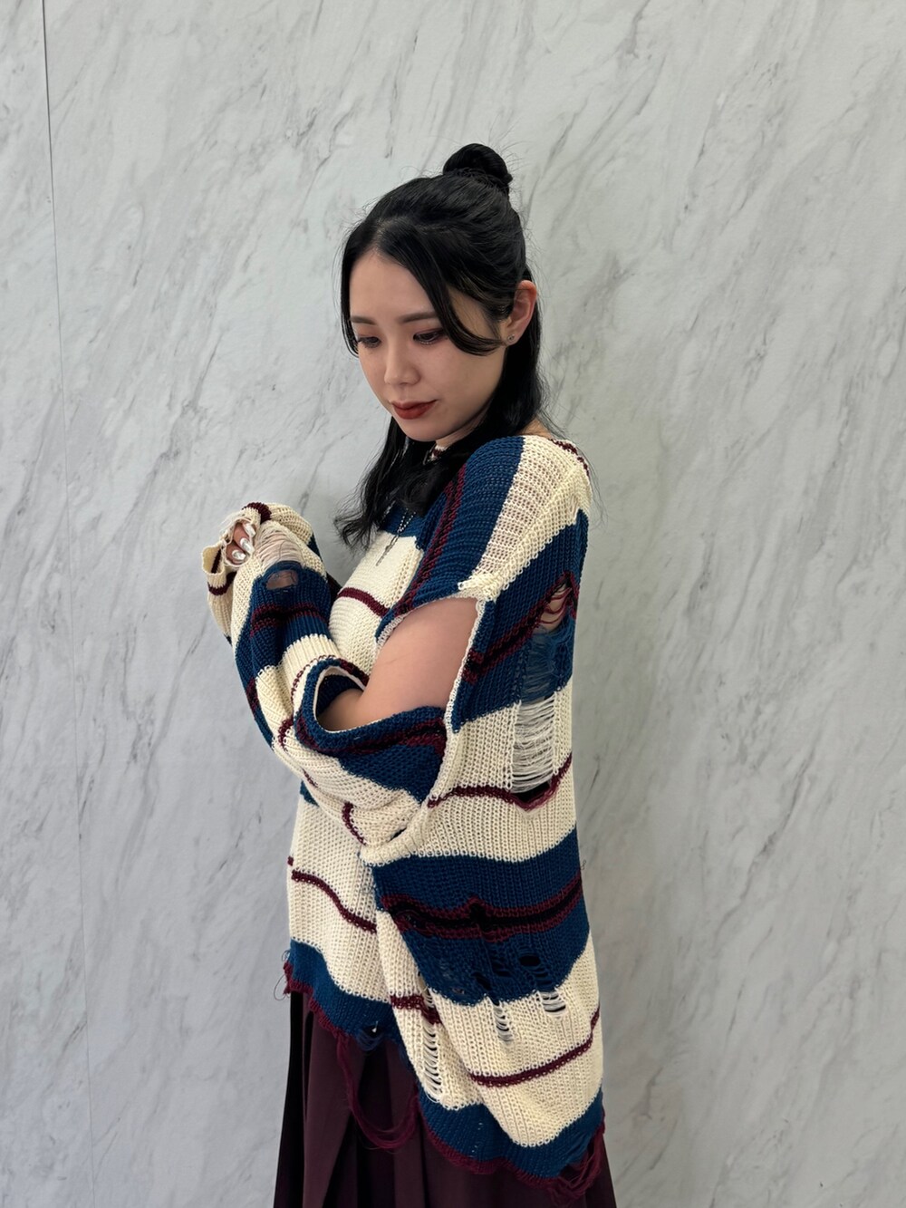 ホワイト系のニット/セーター、レッド系のスカート、ブラック系のブーツを着用したレディースの春コーディネートの5枚目の写真