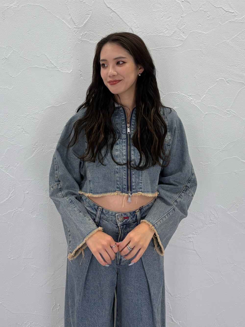 ブルー系のデニムジャケット、ブルー系のデニムパンツ、ブラック系のパンプスを着用したレディースの秋コーディネートの4枚目の写真