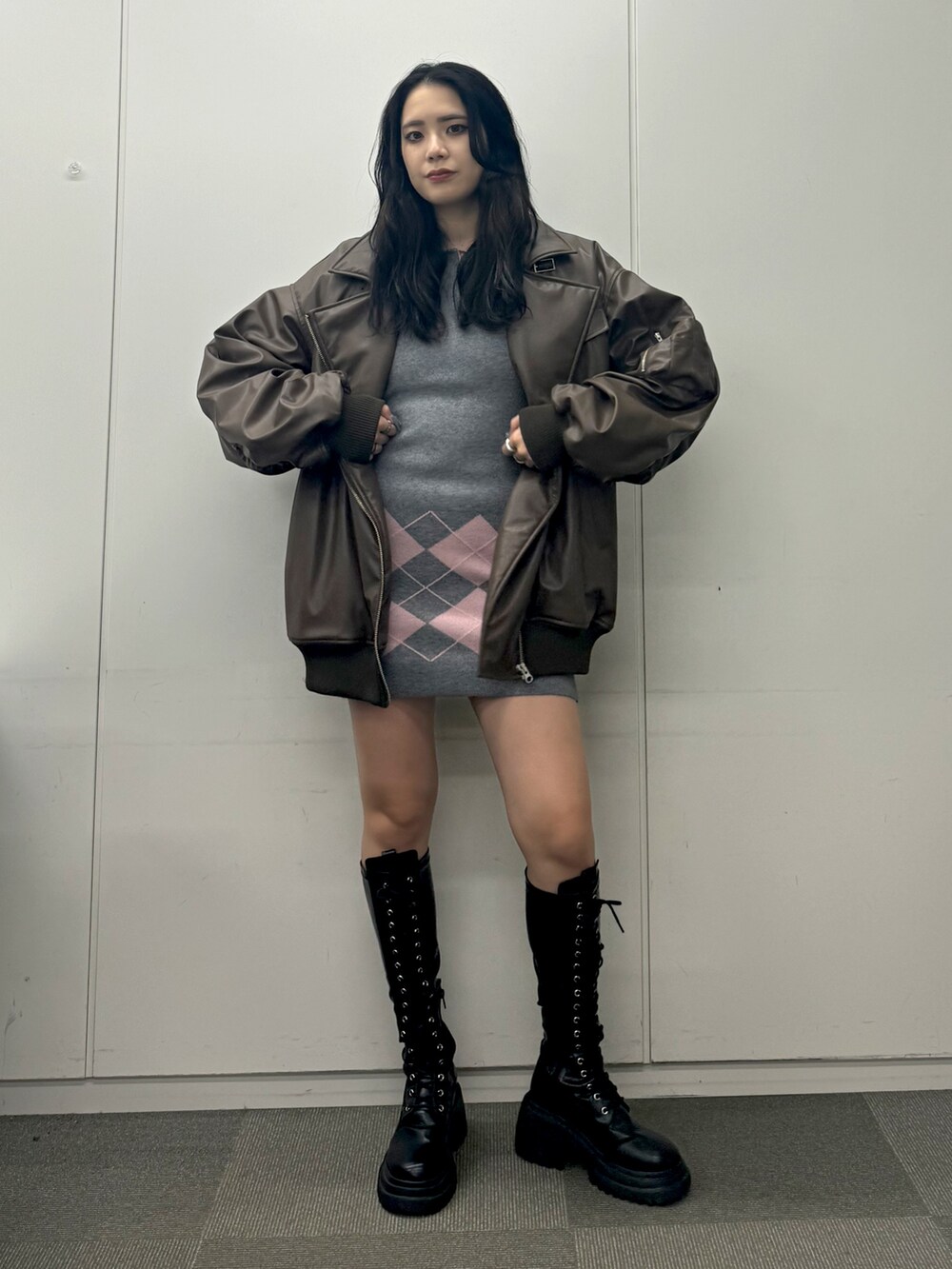 ブラック系のブーツ、ブラウン系のブルゾン、グレー系のワンピースを着用したレディースの秋コーディネートの2枚目の写真