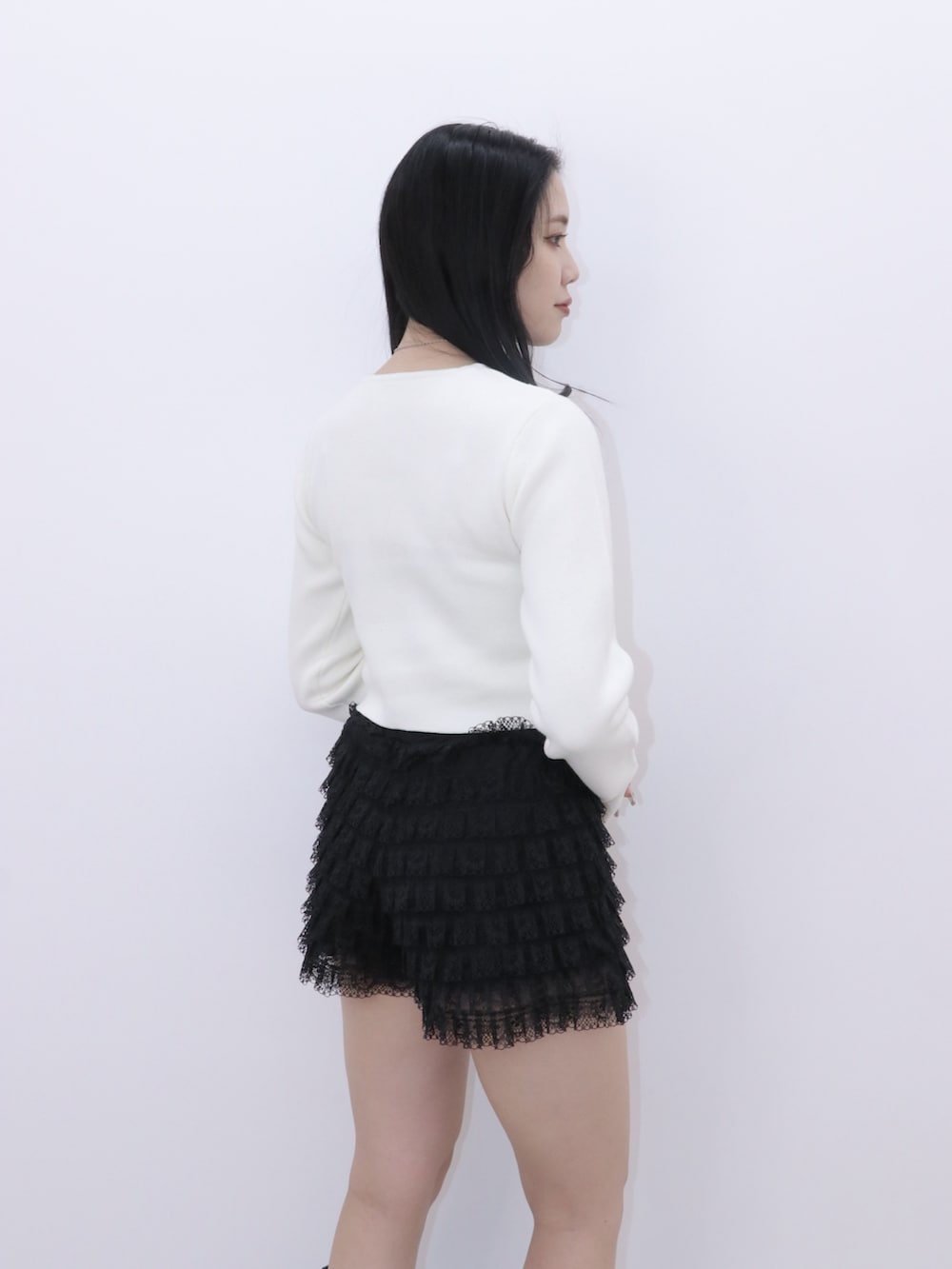 ブラック系のその他パンツ、ホワイト系のカーディガン/ボレロ、ブラック系のブーツを着用したレディースの冬コーディネートの4枚目の写真