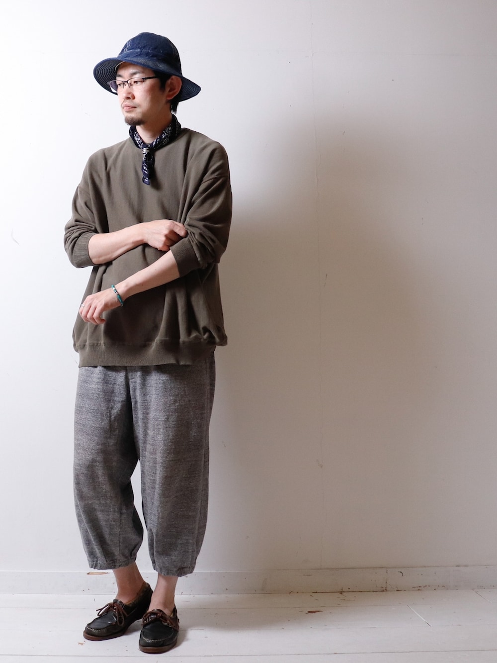 グリーン系のニット/セーター、グレー系のスウェットパンツ、グリーン系のモカシン/デッキシューズを着用したメンズの春コーディネートの2枚目の写真