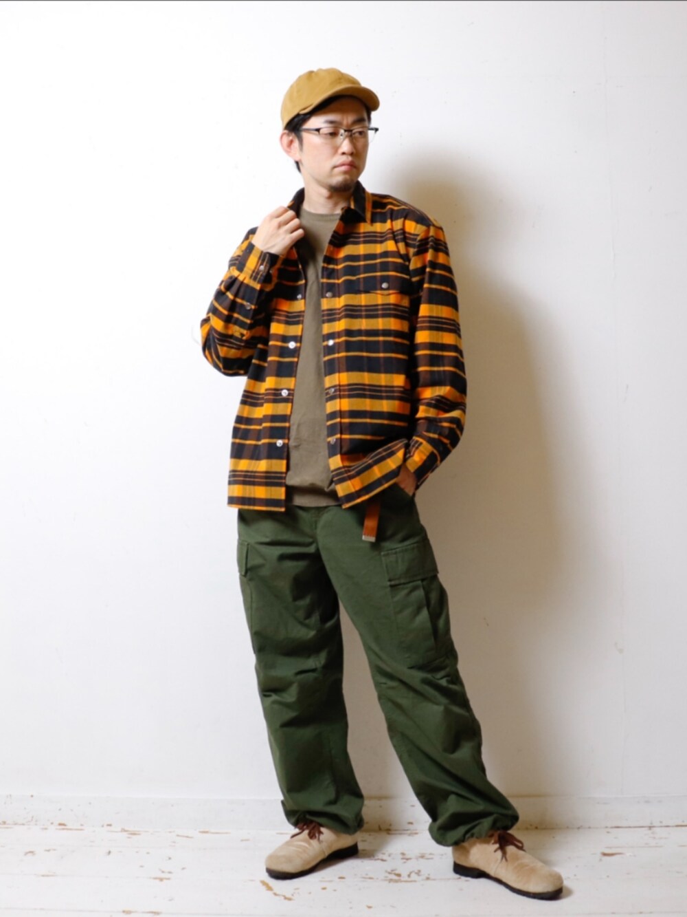 オレンジ系のシャツ/ブラウス、グリーン系のカーゴパンツ、ベージュ系のブーツを着用したメンズの秋コーディネートの2枚目の写真