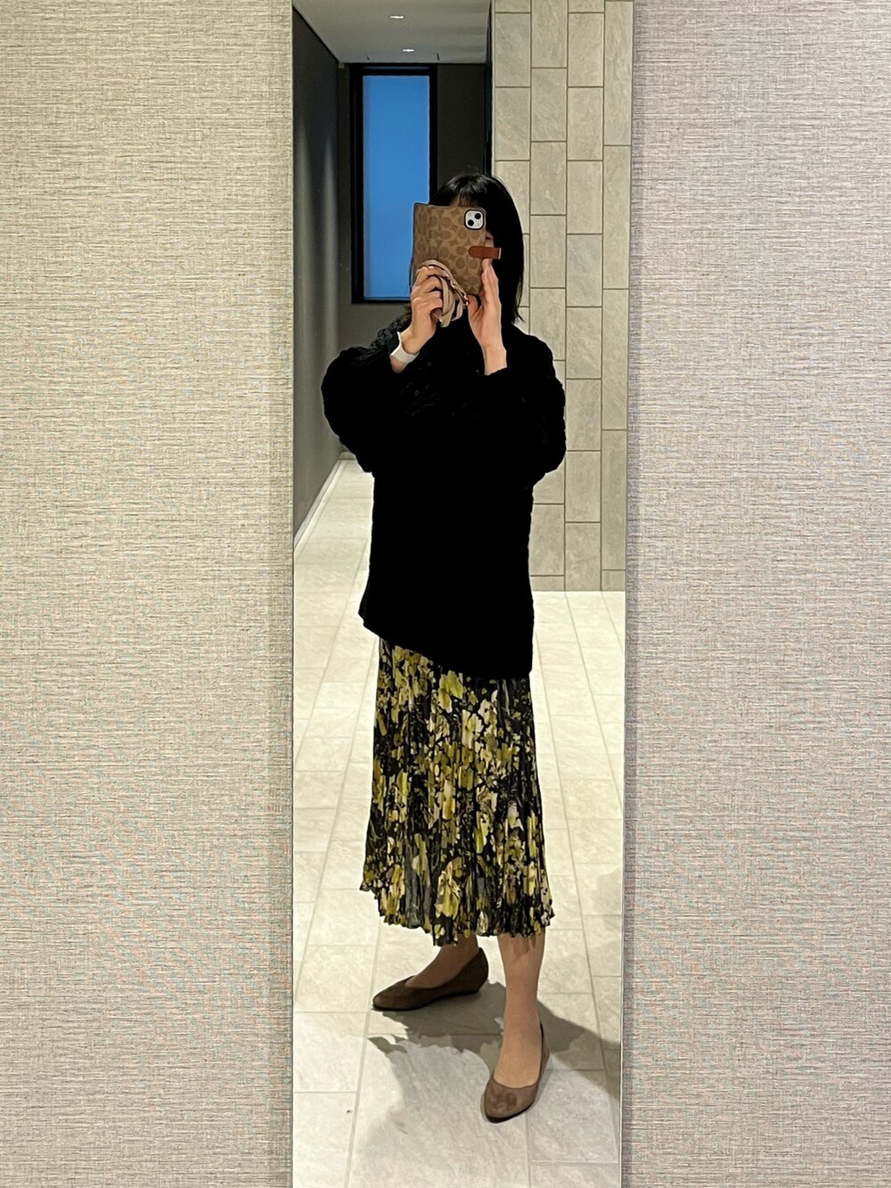 ブラック系のニット/セーター、ブラック系のスカートを着用したレディースの冬コーディネートの2枚目の写真