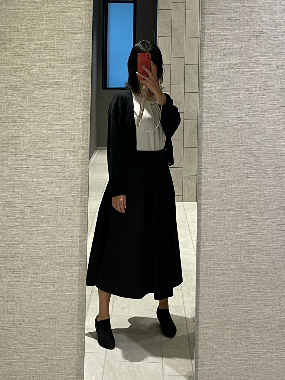 ブラック系のスカート、ブラック系のシューズ、ホワイト系のシャツ/ブラウスを着用したレディースの夏コーディネートの2枚目の写真