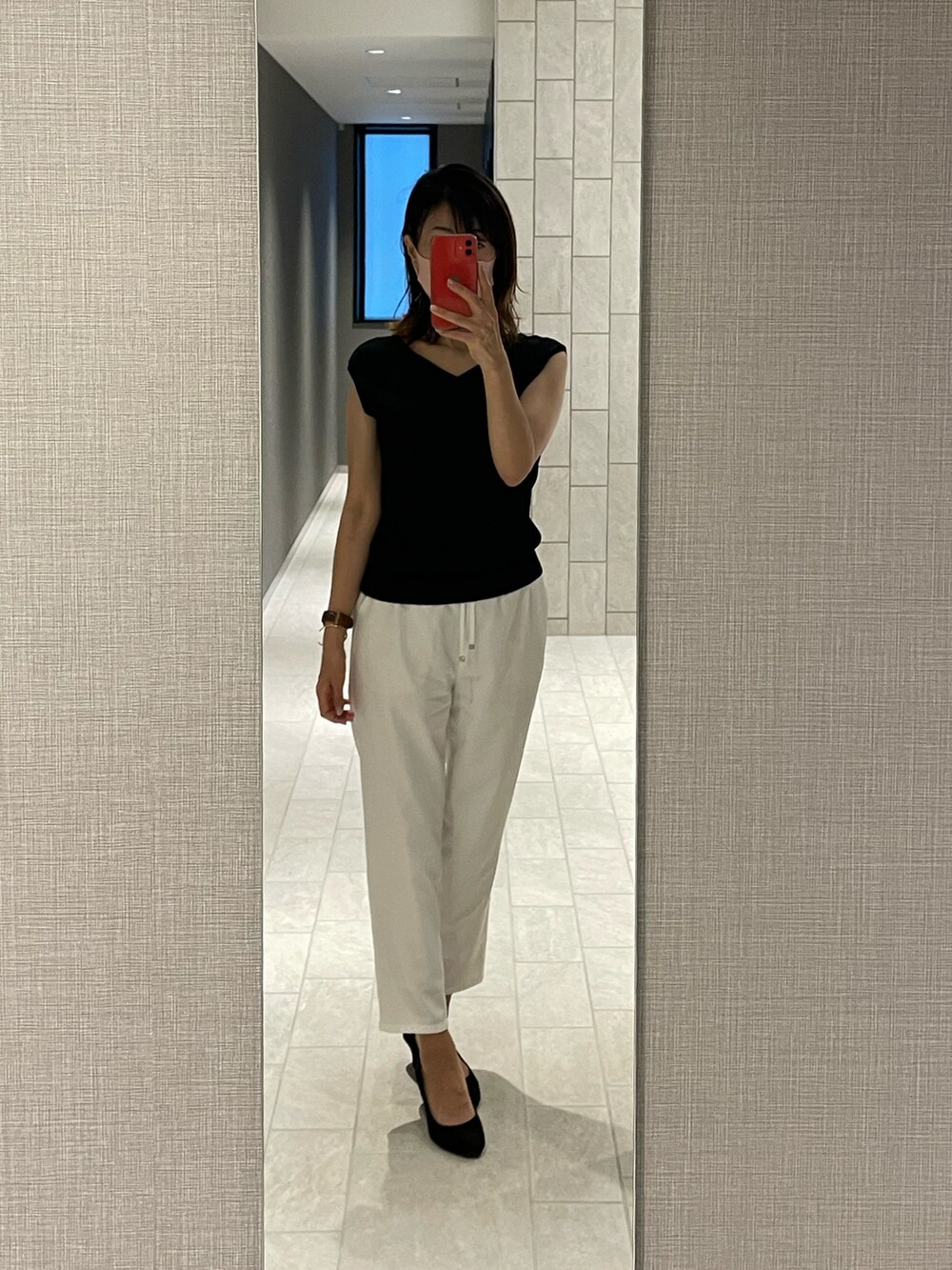 ブラック系のTシャツ/カットソー、ホワイト系のスラックスを着用したレディースの夏コーディネートの2枚目の写真