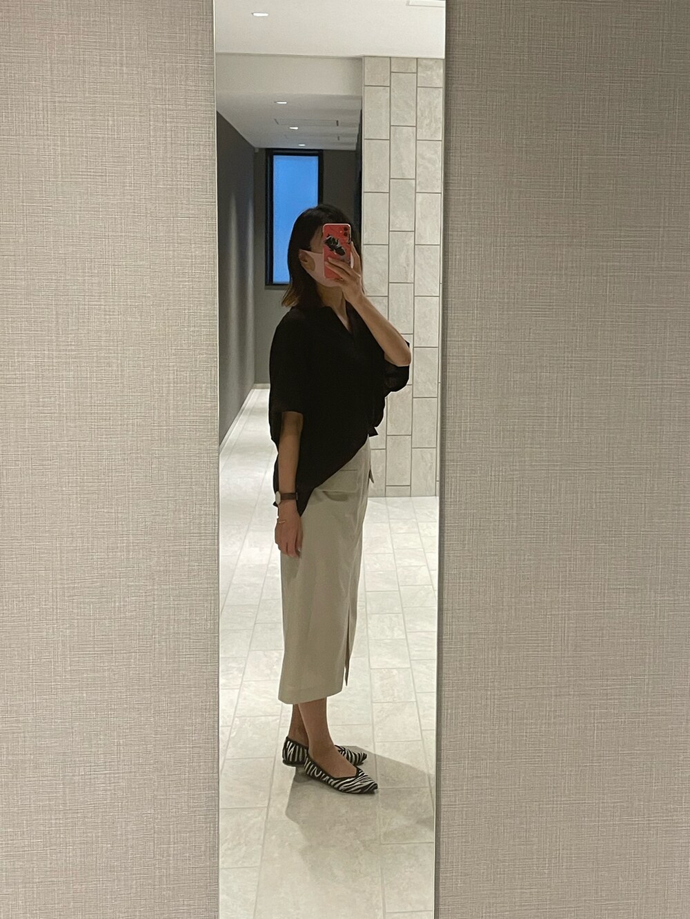 ブラック系のシャツ/ブラウス、ホワイト系のパンプスを着用したレディースの夏コーディネートの2枚目の写真