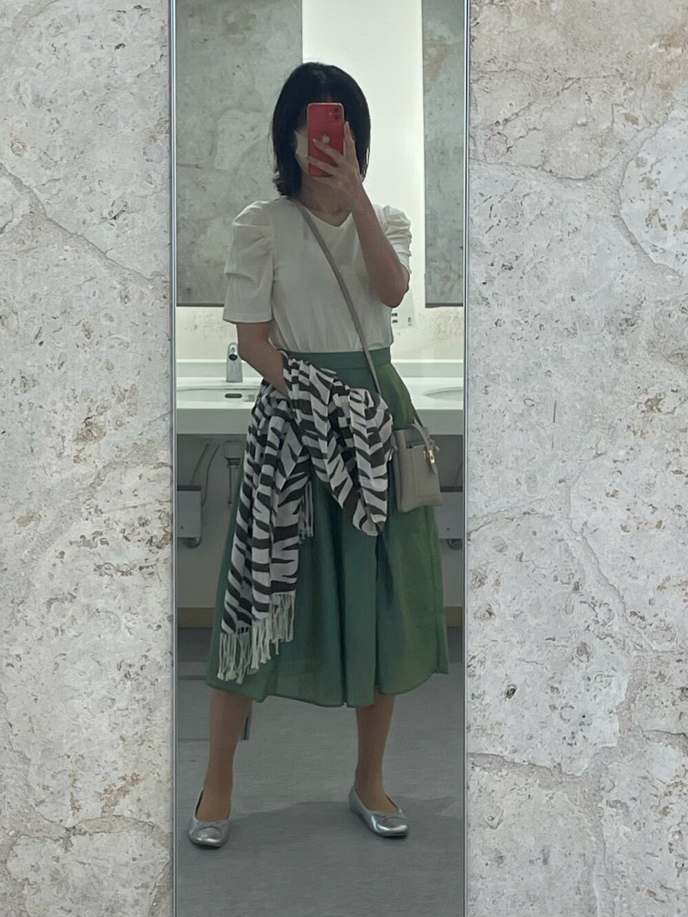 グリーン系のスカート、ホワイト系のTシャツ/カットソー、グレー系のショルダーバッグを着用したレディースの春コーディネートの2枚目の写真