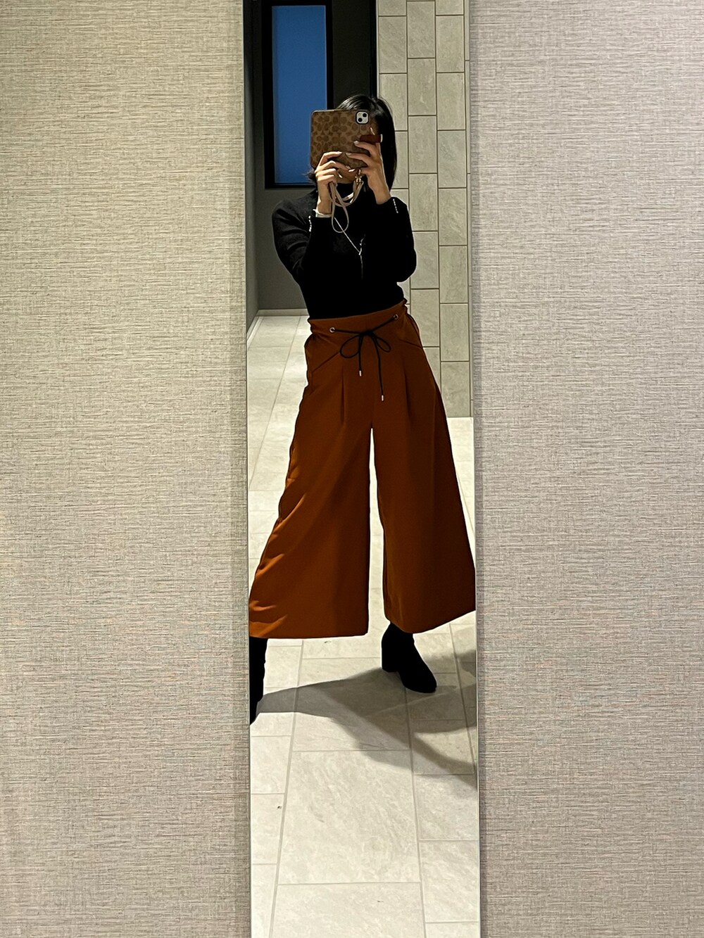 ブラック系のブーツを着用したレディースの冬コーディネートの2枚目の写真