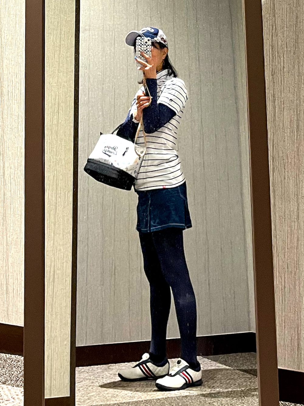 ホワイト系のスニーカー、ブルー系のパンツ、ホワイト系のトップスを着用したレディースの秋コーディネートの2枚目の写真