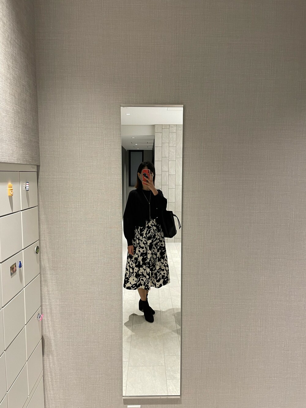 ブラック系のトートバッグ、ブラック系のTシャツ/カットソー、ブラック系のカーディガン/ボレロを着用したレディースの秋コーディネートの2枚目の写真