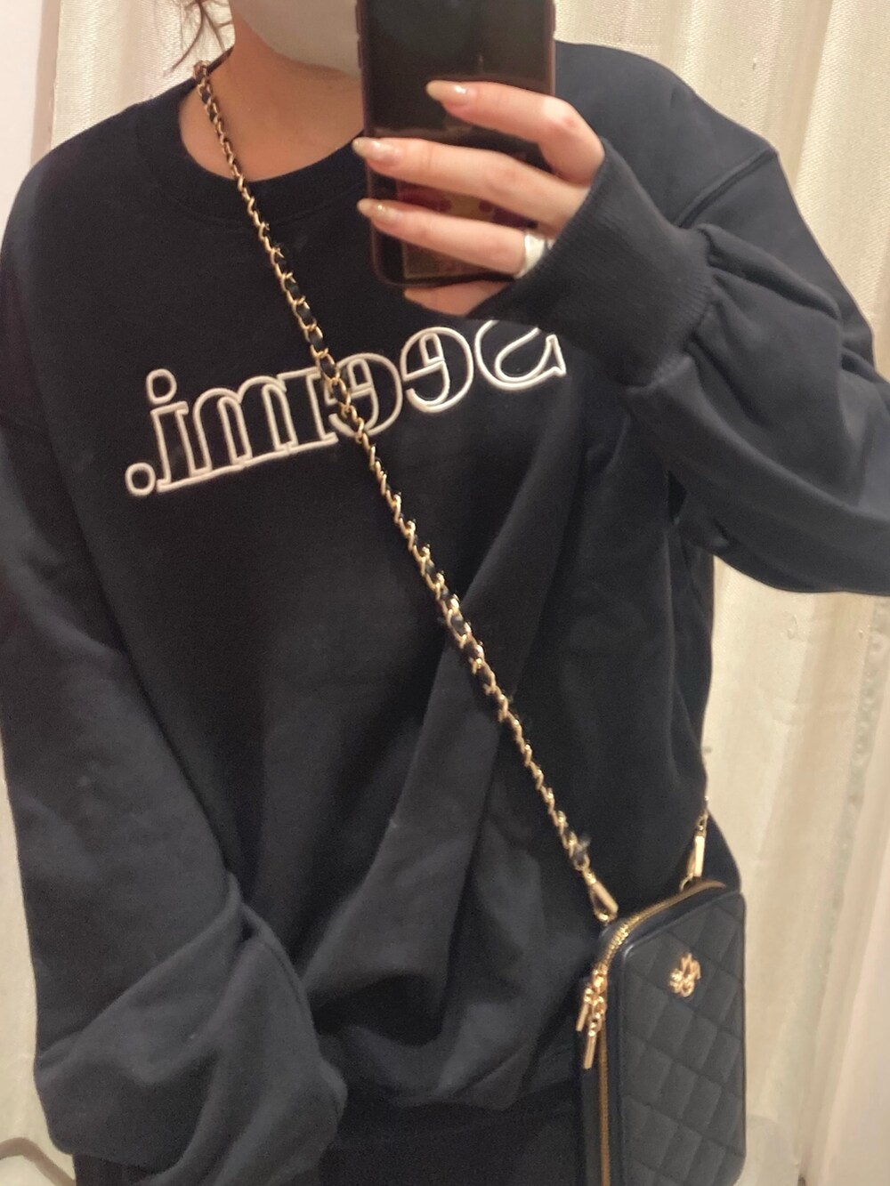 ブラック系のスウェット、ブラック系のワンピース、ブラック系のブーツを着用したレディースの秋コーディネートの3枚目の写真