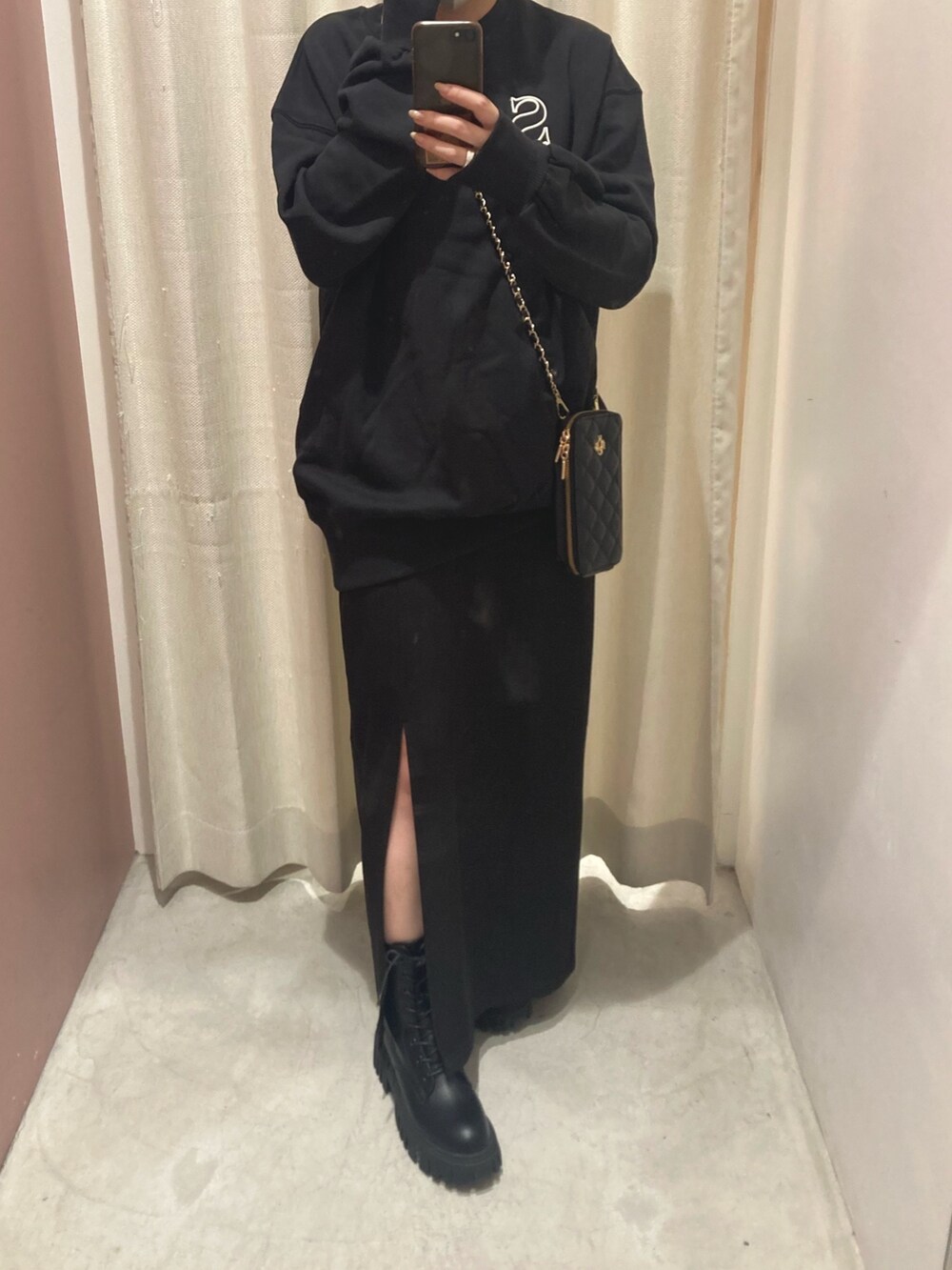 ブラック系のスウェット、ブラック系のワンピース、ブラック系のブーツを着用したレディースの秋コーディネートの2枚目の写真