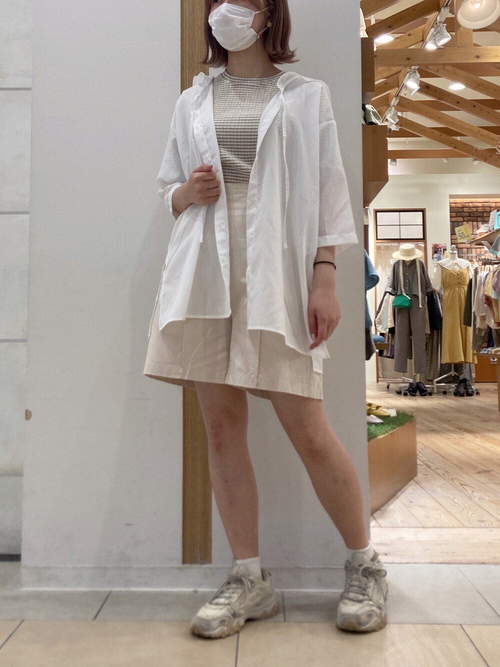 ホワイト系のチュニック、ベージュ系のシャツ/ブラウス、ホワイト系のその他パンツを着用したレディースの春コーディネートの2枚目の写真