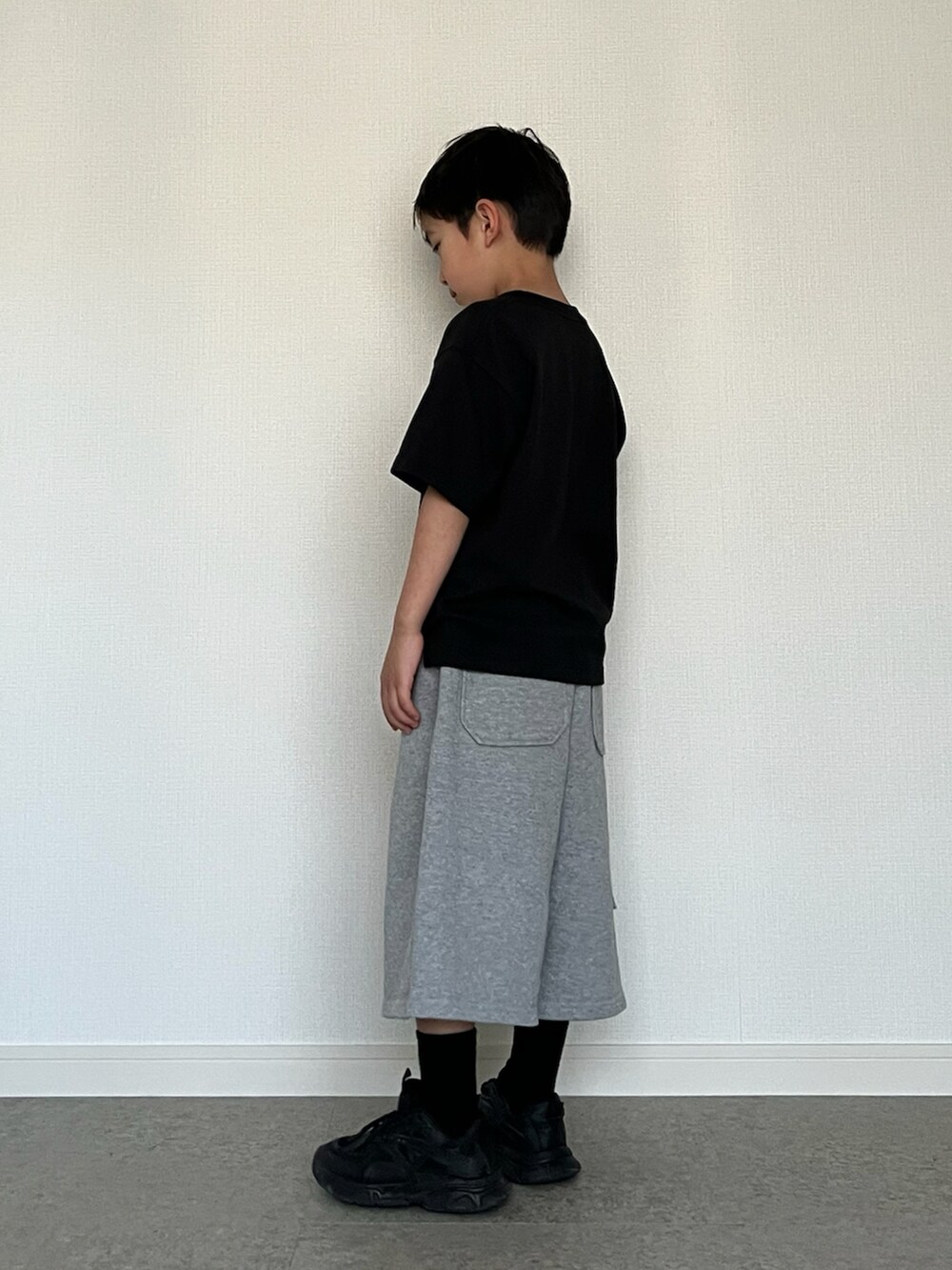 ブラック系のスニーカー、ブラック系のTシャツ/カットソー、グレー系のスウェットパンツを着用したキッズの春コーディネートの2枚目の写真