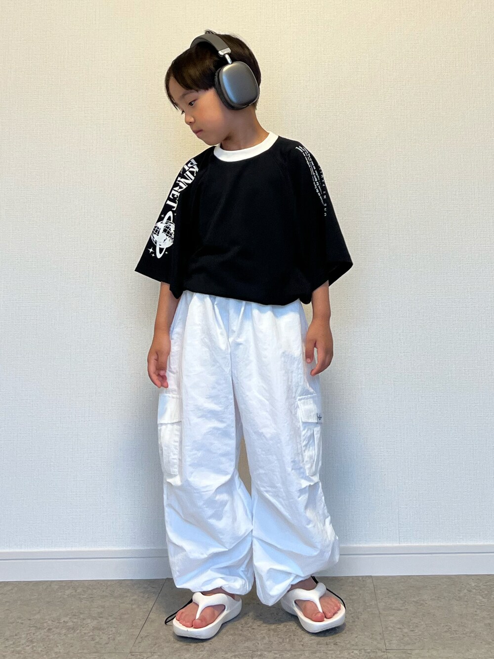 ブラック系のTシャツ/カットソー、ホワイト系のカーゴパンツ、ホワイト系のサンダルを着用したキッズの夏コーディネートの3枚目の写真