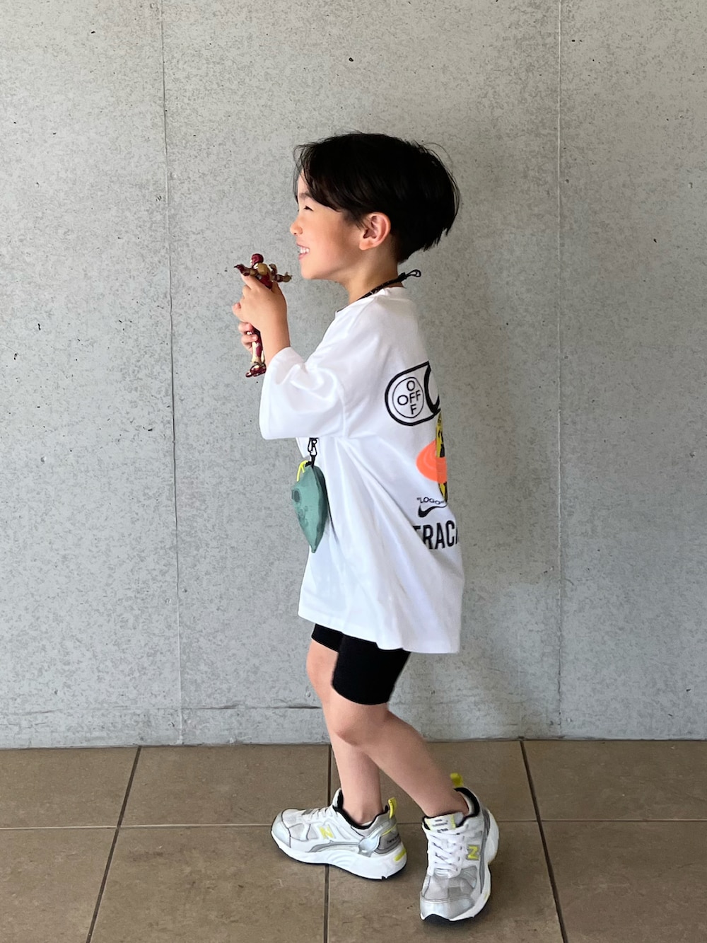 ホワイト系のTシャツ/カットソー、ブラック系のパンツ、シルバー系のスニーカーを着用したキッズの春コーディネートの2枚目の写真