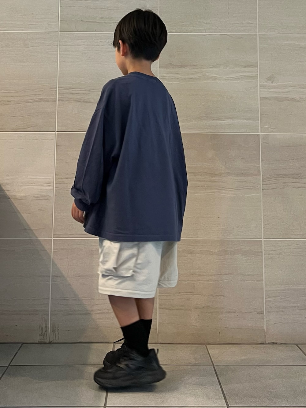 ブルー系のTシャツ/カットソー、ホワイト系のカーゴパンツ、ブラック系のスニーカーを着用したキッズの秋コーディネートの2枚目の写真