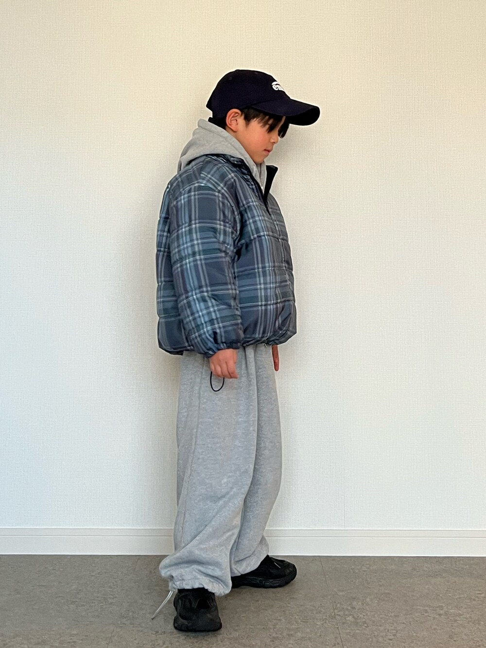 ブラック系のスニーカー、グレー系のスウェットパンツ、グレー系のパーカーを着用したキッズの冬コーディネートの3枚目の写真