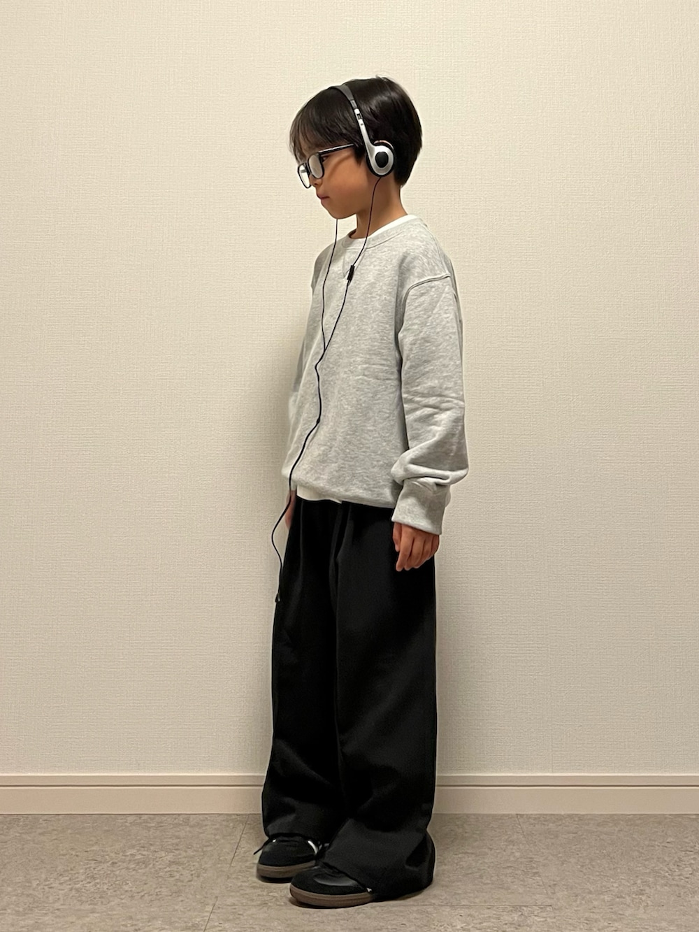 ブラック系のスラックス、ブルー系のスウェット、ホワイト系のTシャツ/カットソーを着用したキッズの秋コーディネートの2枚目の写真