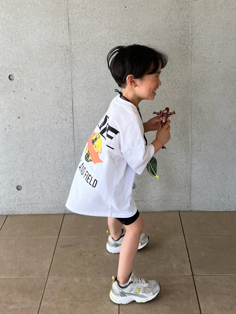 ホワイト系のTシャツ/カットソー、ブラック系のパンツ、シルバー系のスニーカーを着用したキッズの春コーディネートの3枚目の写真