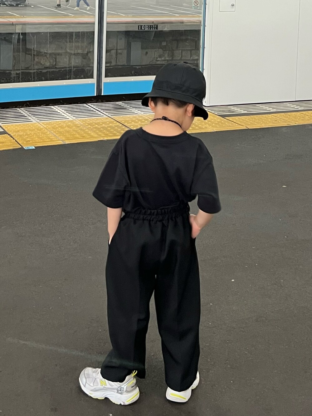 ブラック系のTシャツ/カットソー、ブラック系のスラックス、シルバー系のスニーカーを着用したキッズの夏コーディネートの2枚目の写真