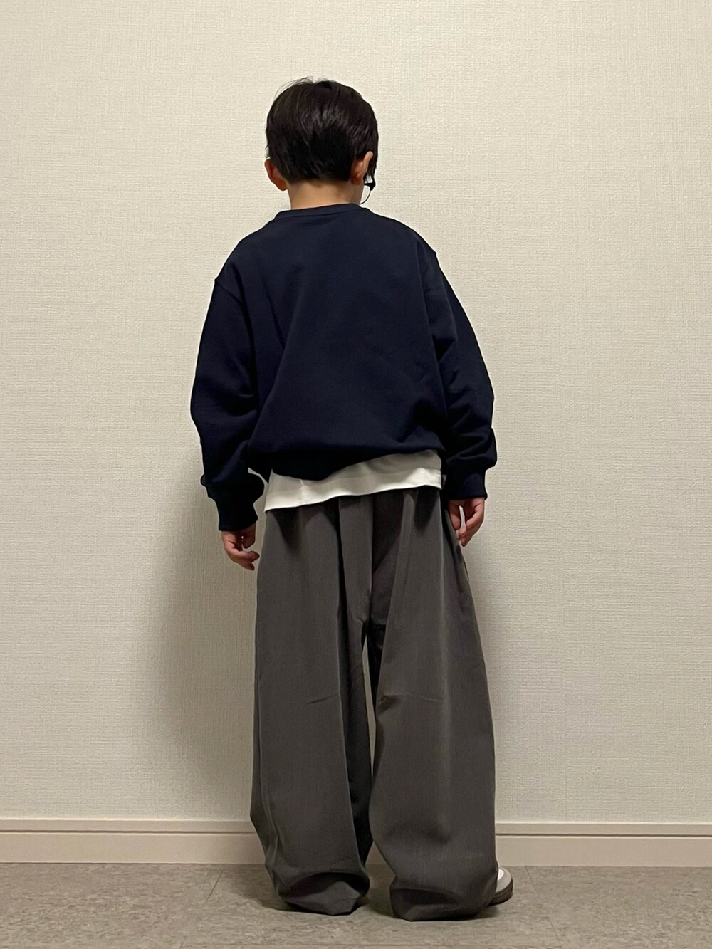 グレー系のスラックス、ブルー系のスウェット、ホワイト系のTシャツ/カットソーを着用したキッズの秋コーディネートの2枚目の写真