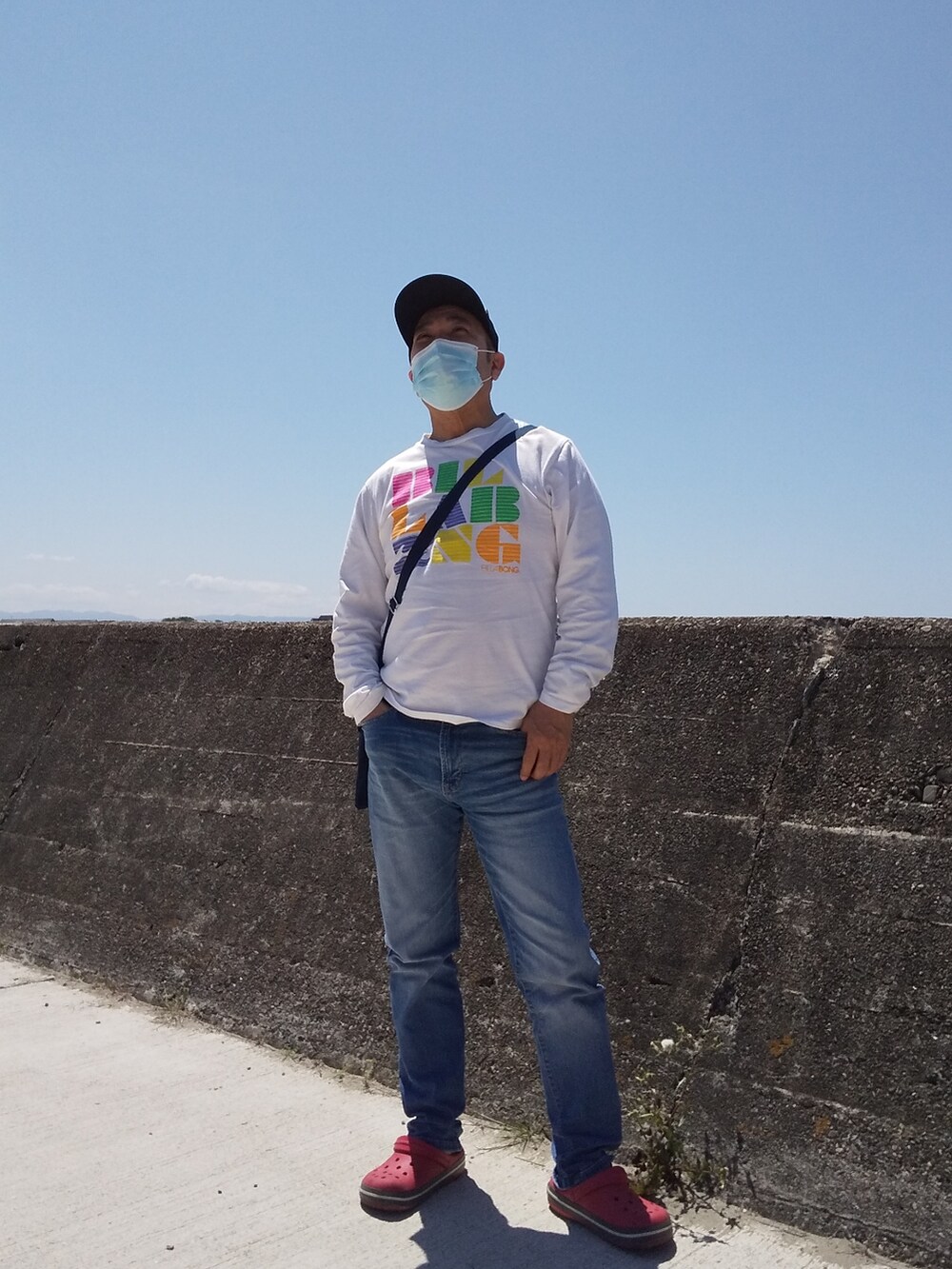 ホワイト系のTシャツ/カットソー、レッド系のサンダル、グレー系のキャップを着用したレディースの夏コーディネートの2枚目の写真