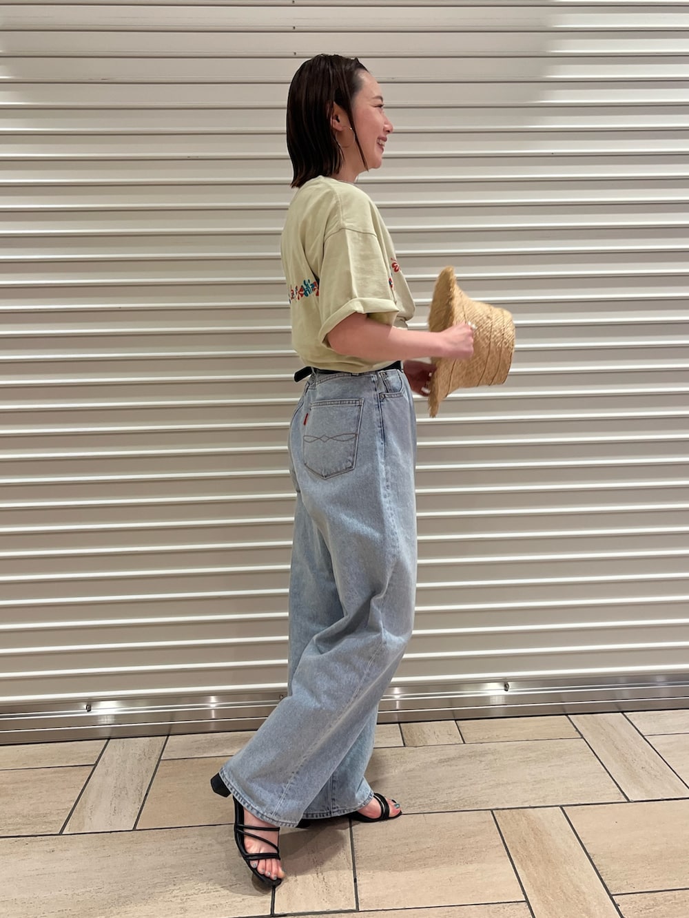 ブルー系のデニムパンツ、ベージュ系のTシャツ/カットソー、ベージュ系のハットを着用したレディースの夏コーディネートの2枚目の写真