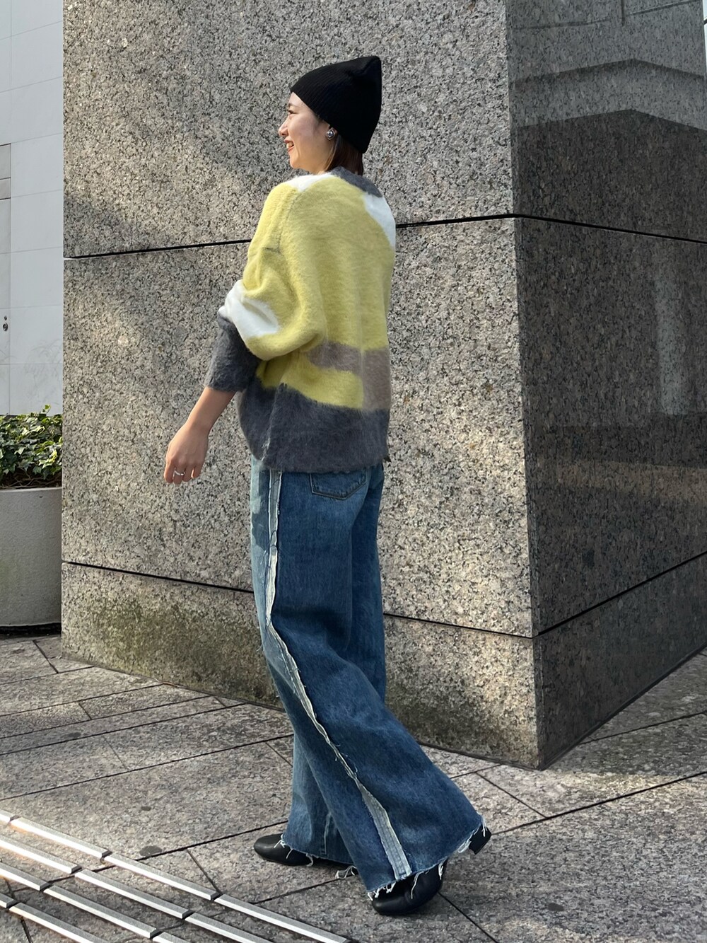 グリーン系のニット/セーター、ブルー系のデニムパンツ、ブラック系のニットキャップ/ビーニーを着用したレディースの秋コーディネートの2枚目の写真