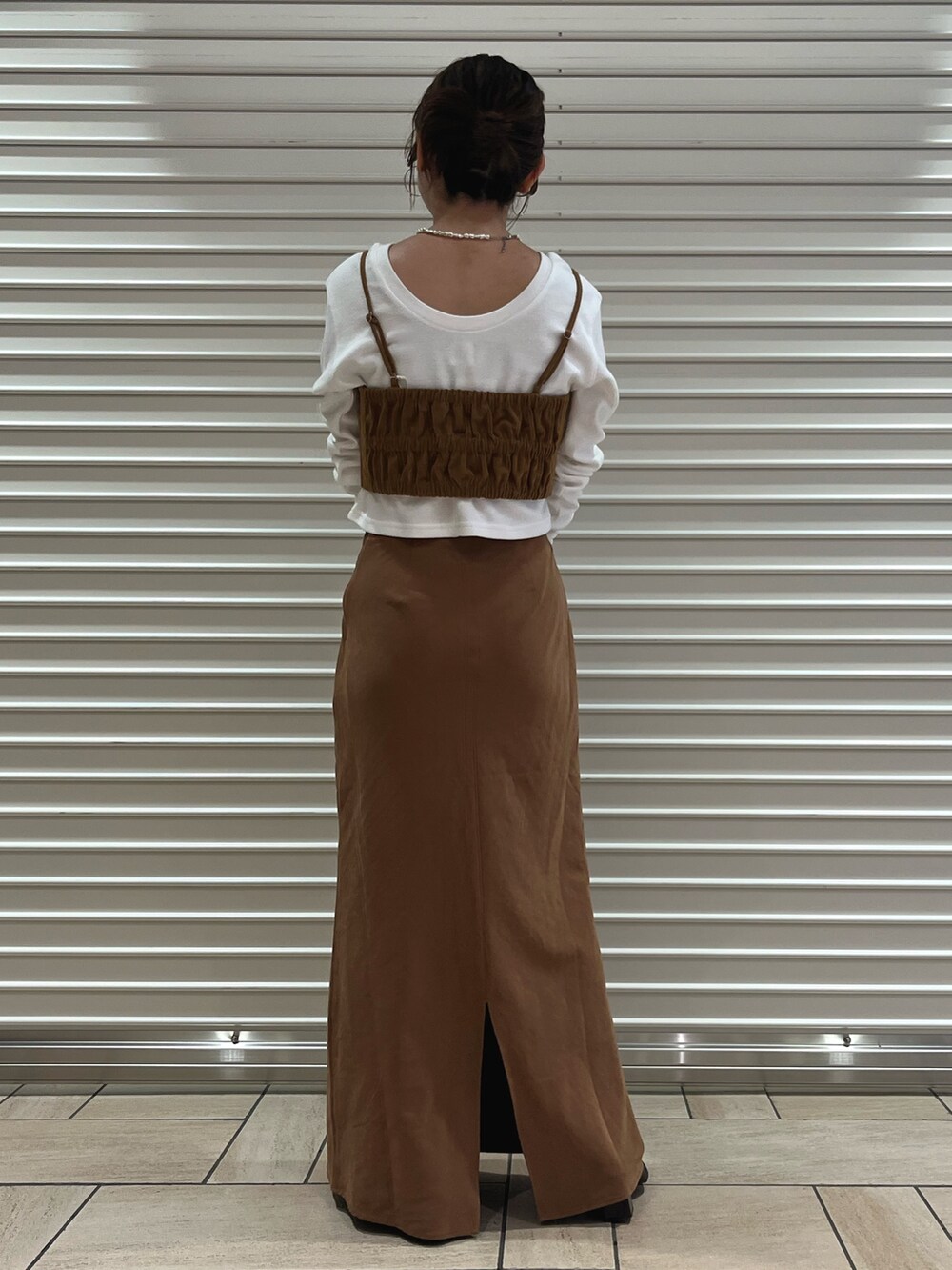 ブラウン系のキャミソール、ブラウン系のスカート、ホワイト系のTシャツ/カットソーを着用したレディースの秋コーディネートの3枚目の写真