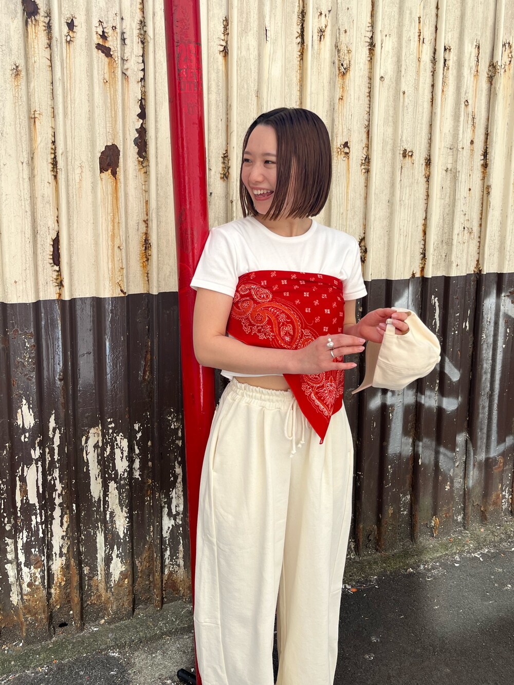 ホワイト系のTシャツ/カットソー、ホワイト系のスウェットパンツ、レッド系のストール/ショールを着用したレディースの春コーディネートの5枚目の写真