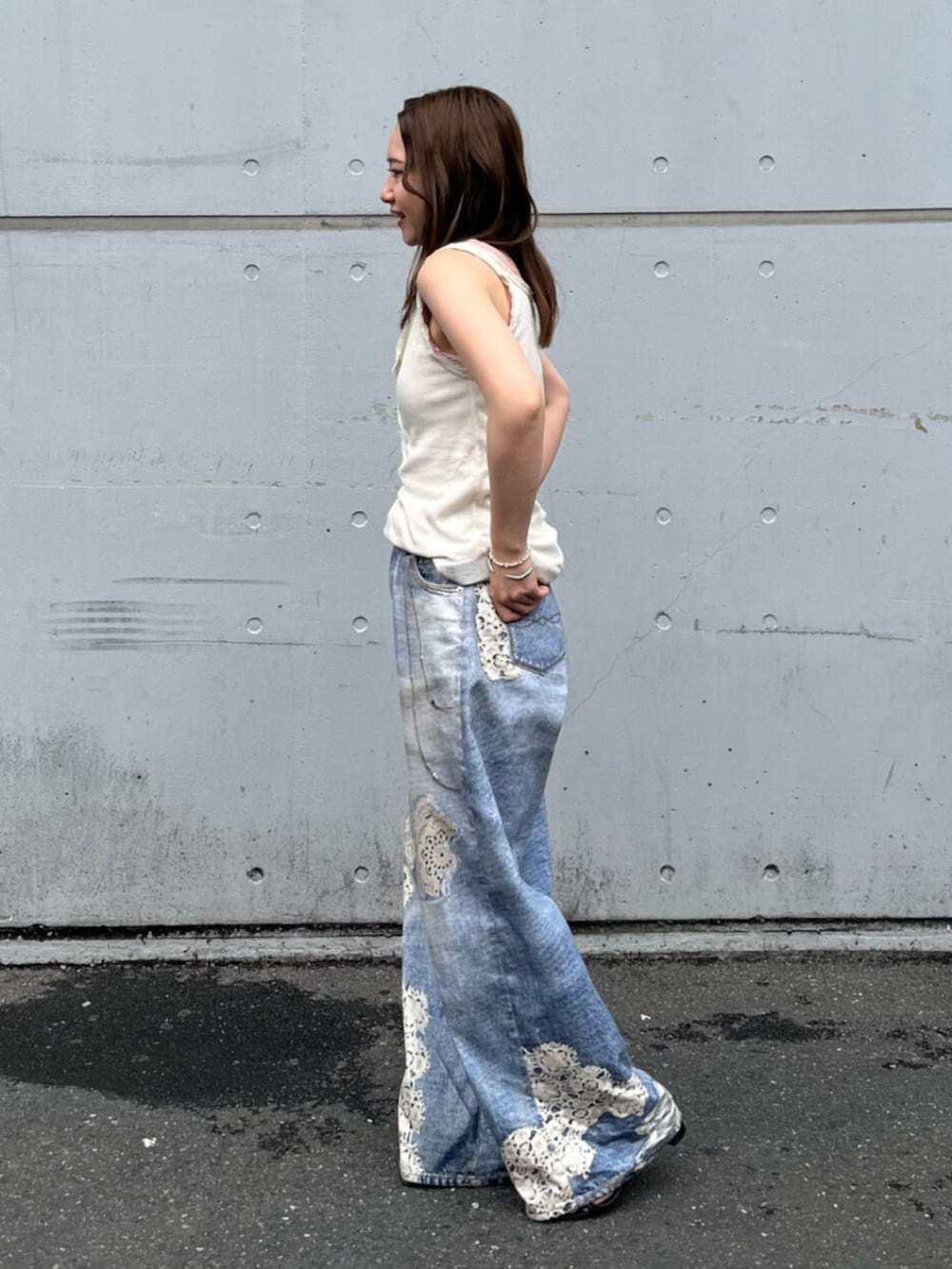 ブルー系のデニムパンツ、ホワイト系のタンクトップ、ピンク系のタンクトップを着用したレディースの夏コーディネートの2枚目の写真