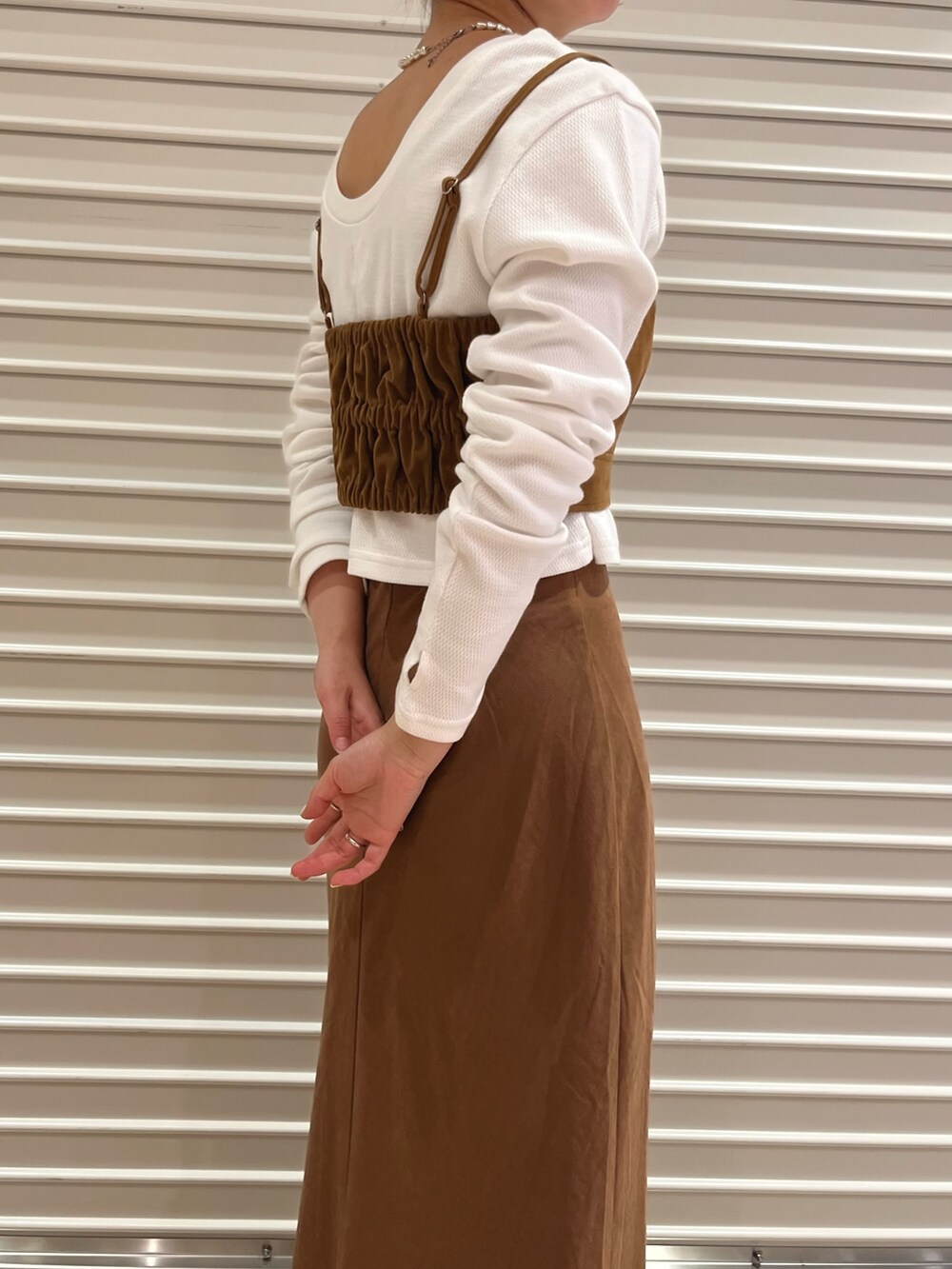 ブラウン系のキャミソール、ブラウン系のスカート、ホワイト系のTシャツ/カットソーを着用したレディースの秋コーディネートの4枚目の写真