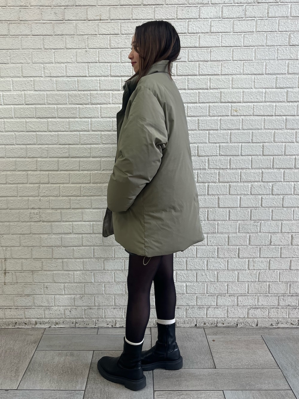 ベージュ系のダウンジャケット/コート、グレー系のスカートを着用したレディースの冬コーディネートの3枚目の写真