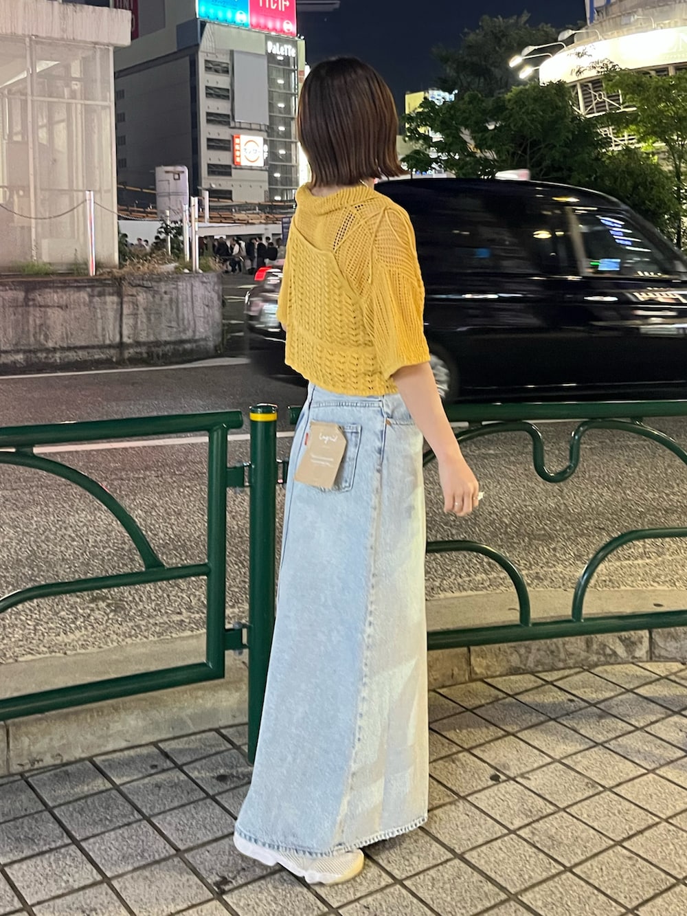 ブルー系のスカート、オレンジ系のカーディガン/ボレロを着用したレディースの春コーディネートの2枚目の写真
