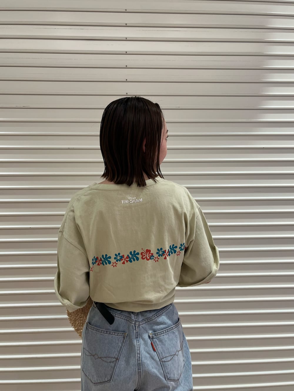 ブルー系のデニムパンツ、ベージュ系のTシャツ/カットソー、ベージュ系のハットを着用したレディースの夏コーディネートの4枚目の写真