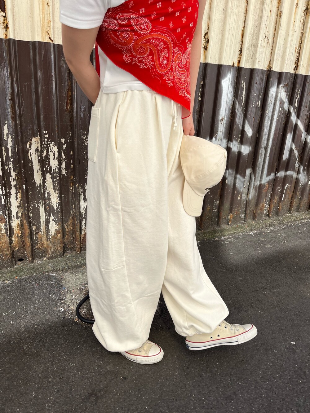 ホワイト系のTシャツ/カットソー、ホワイト系のスウェットパンツ、レッド系のストール/ショールを着用したレディースの春コーディネートの4枚目の写真