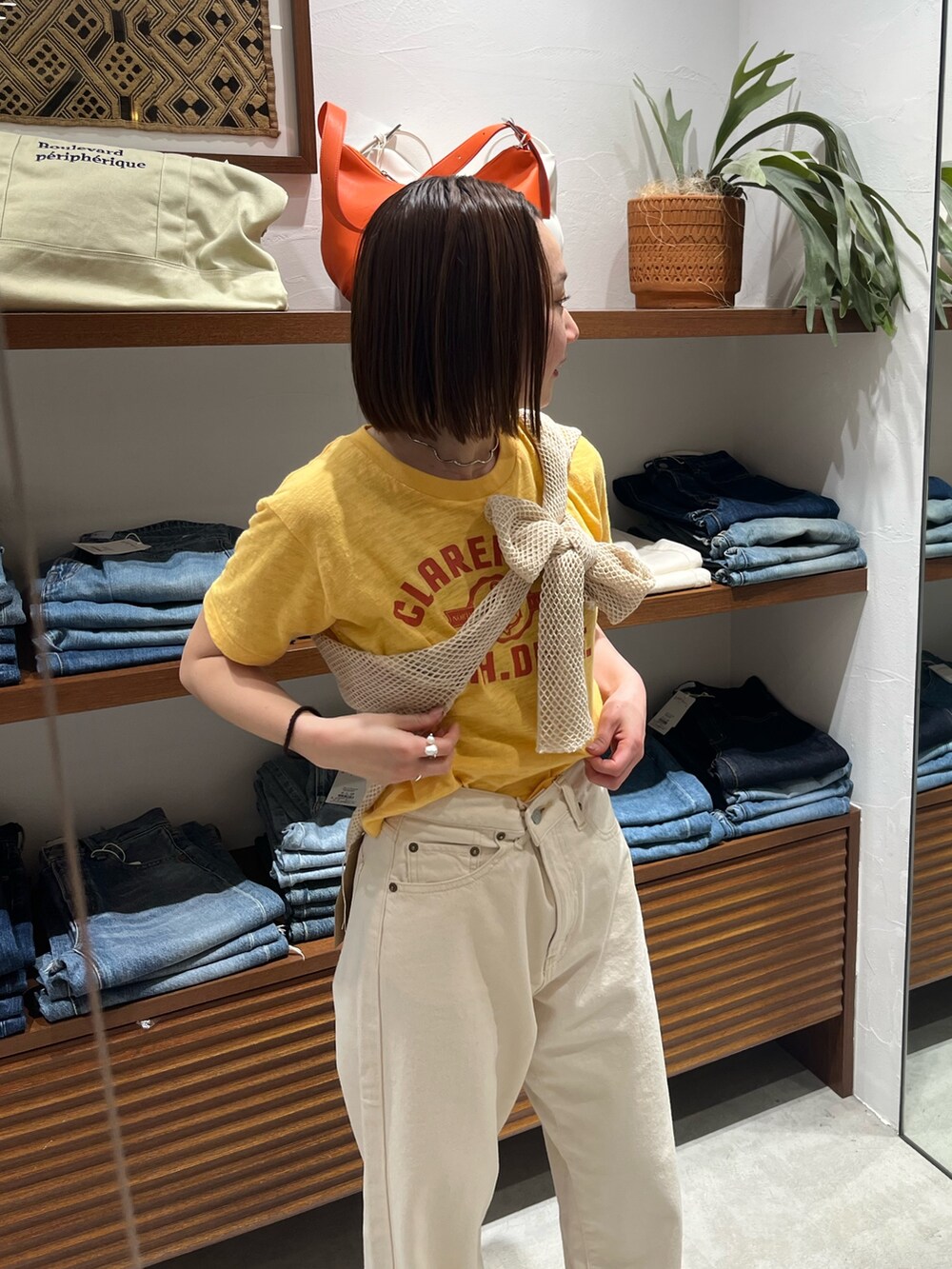 ホワイト系のデニムパンツ、イエロー系のTシャツ/カットソー、ホワイト系のTシャツ/カットソーを着用したレディースの春コーディネートの4枚目の写真