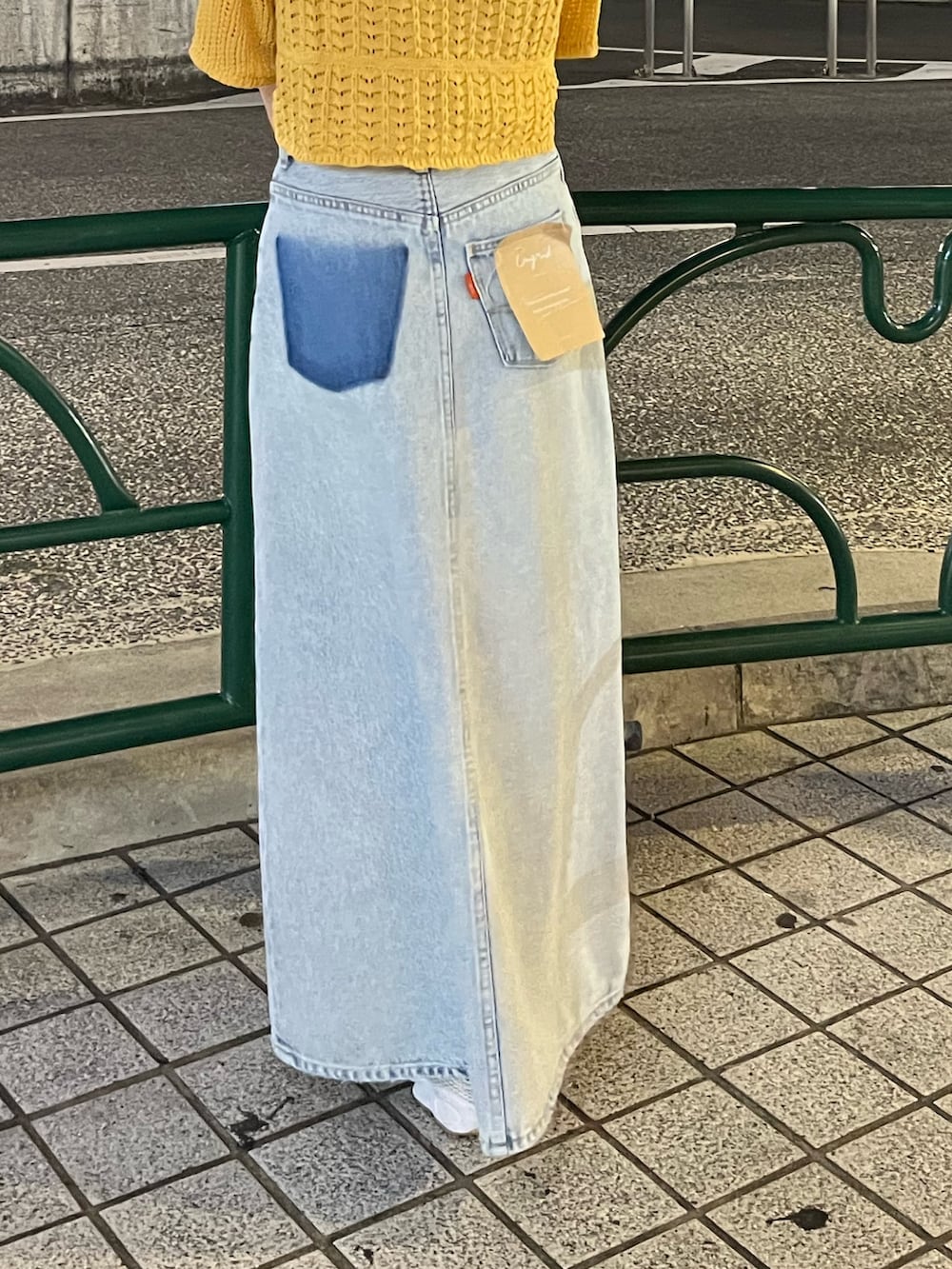 ブルー系のスカート、オレンジ系のカーディガン/ボレロを着用したレディースの春コーディネートの5枚目の写真
