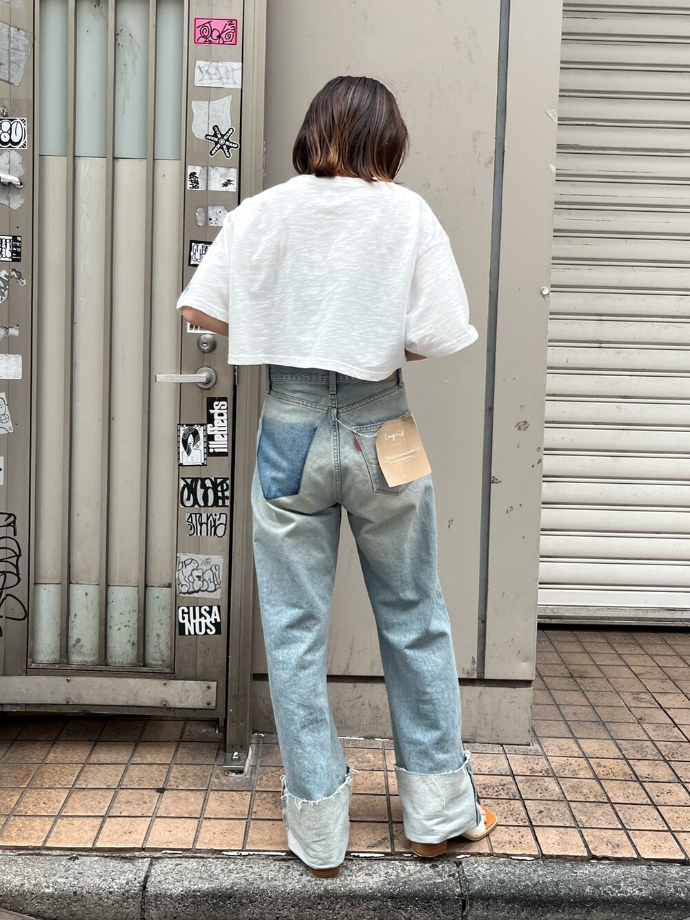 ブルー系のデニムパンツ、ホワイト系のTシャツ/カットソーを着用したレディースの夏コーディネートの2枚目の写真