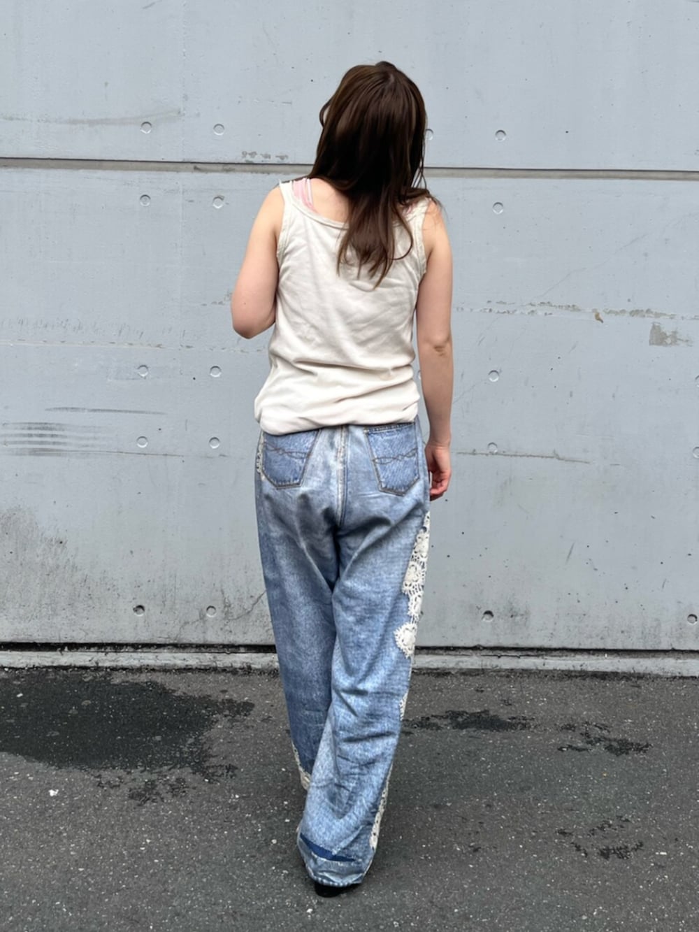 ブルー系のデニムパンツ、ホワイト系のタンクトップ、ピンク系のタンクトップを着用したレディースの夏コーディネートの3枚目の写真