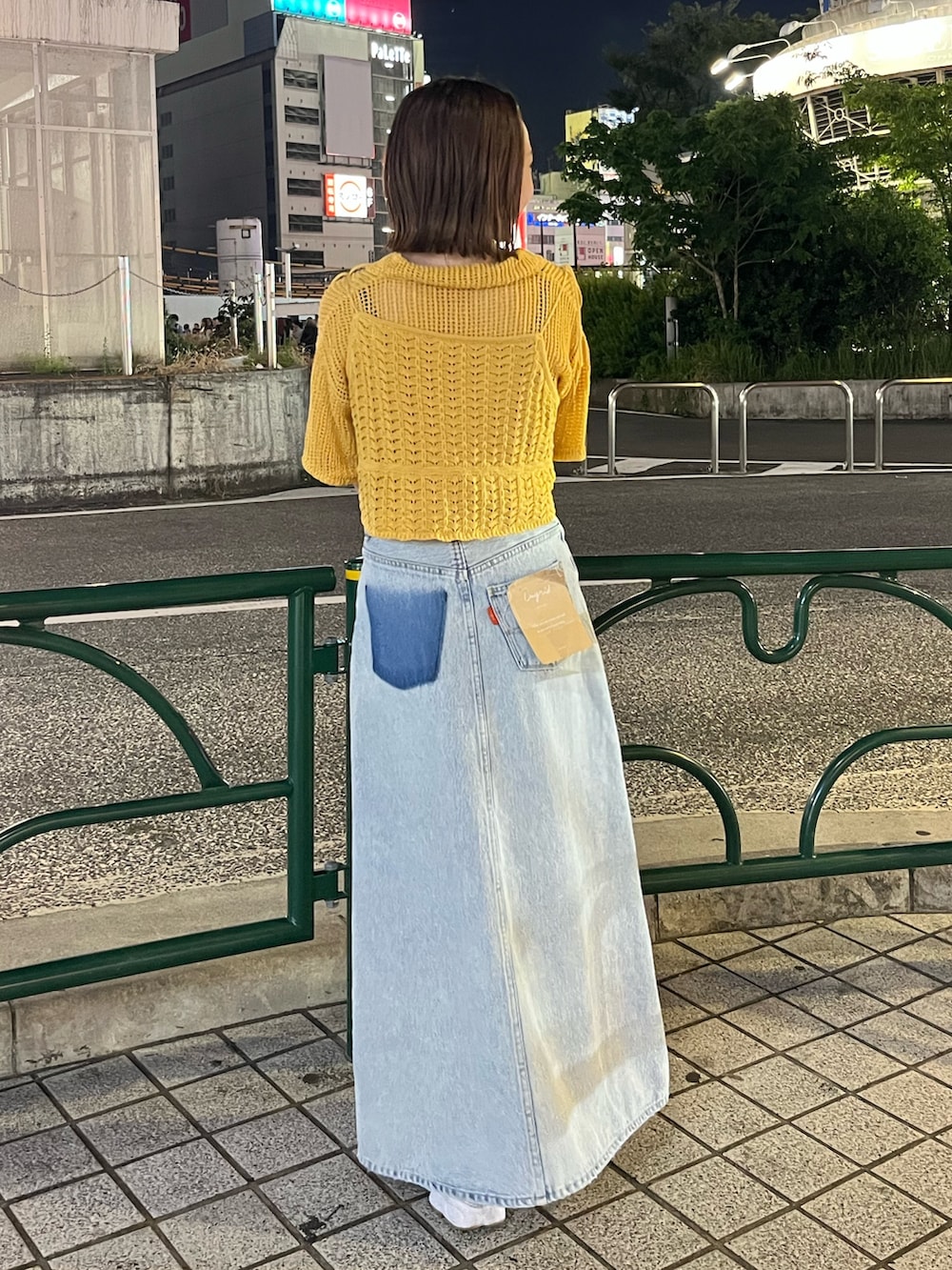 ブルー系のスカート、オレンジ系のカーディガン/ボレロを着用したレディースの春コーディネートの3枚目の写真