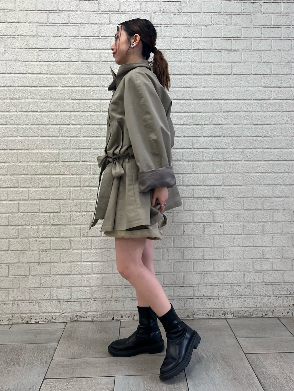 ベージュ系のその他パンツ、グリーン系のトレンチコートを着用したレディースの春コーディネートの2枚目の写真