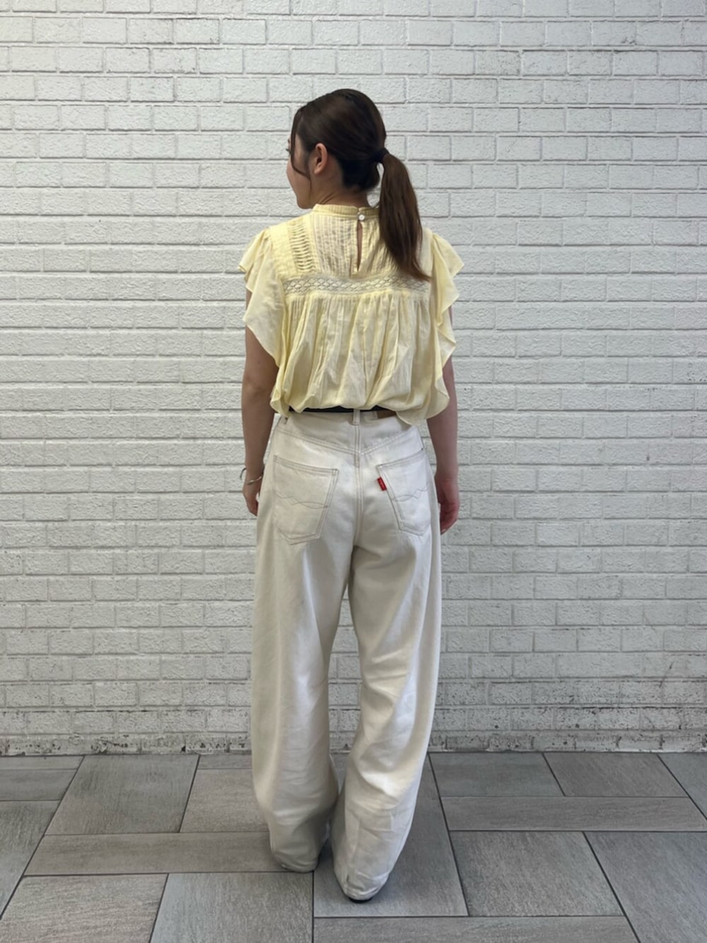 イエロー系のシャツ/ブラウス、ホワイト系のデニムパンツ、ブラウン系のベルトを着用したレディースの夏コーディネートの3枚目の写真